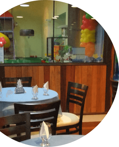 Mesa decorada Imagem com as bordas redondas, colada na lateral esquerda, com uma imagem interna, de uma mesa azul, com decoração em cima dela